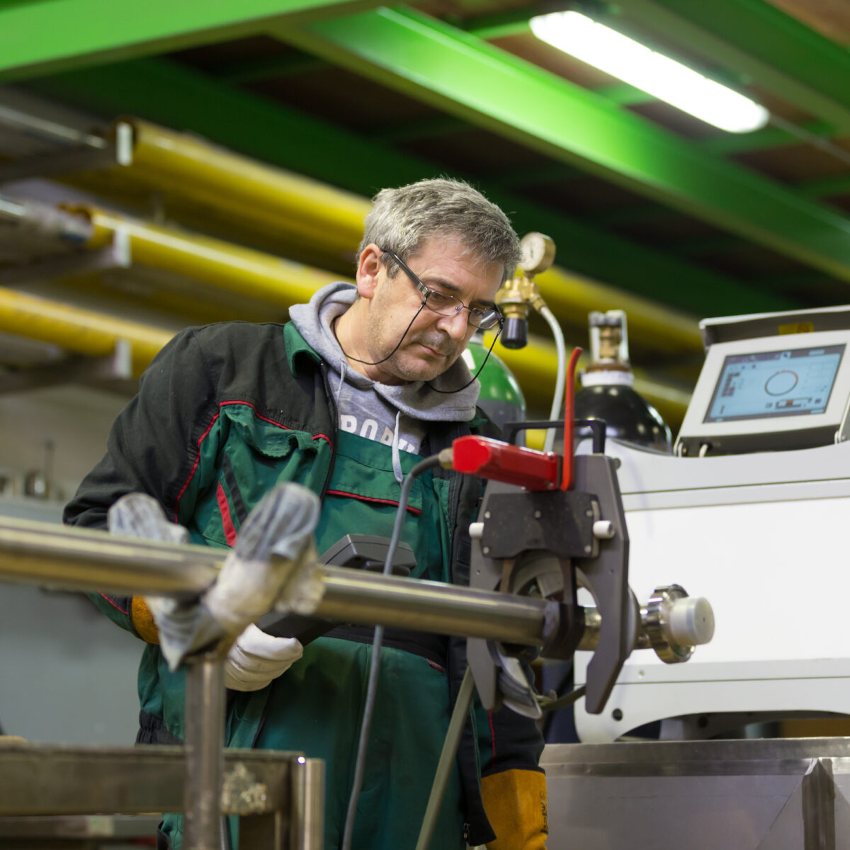 industrial worker setting orbital welding machine.